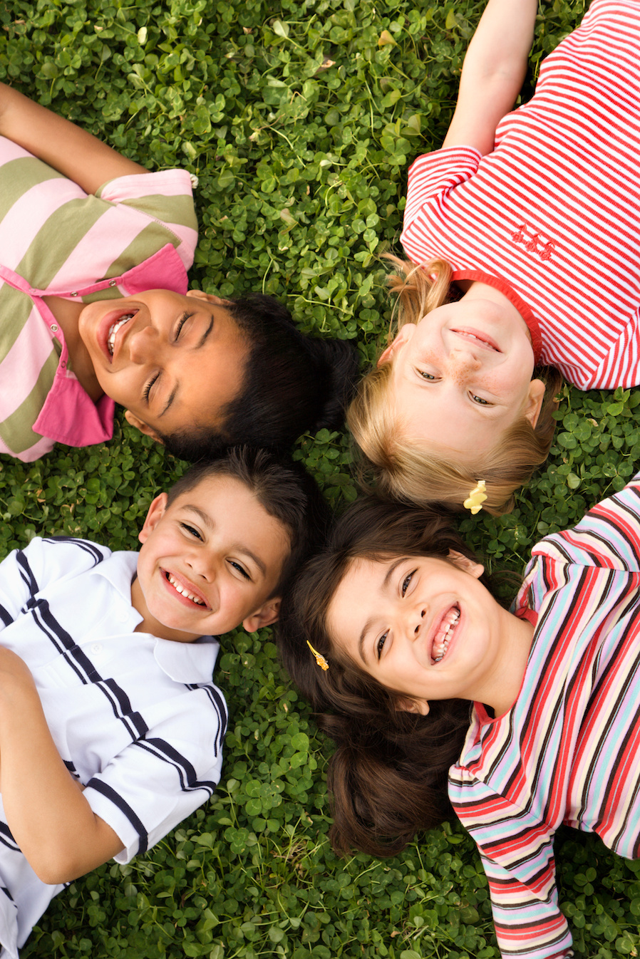 Children Lying in Clover With Heads Together